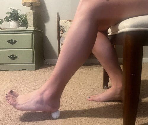 sitting down foot massage with golf ball